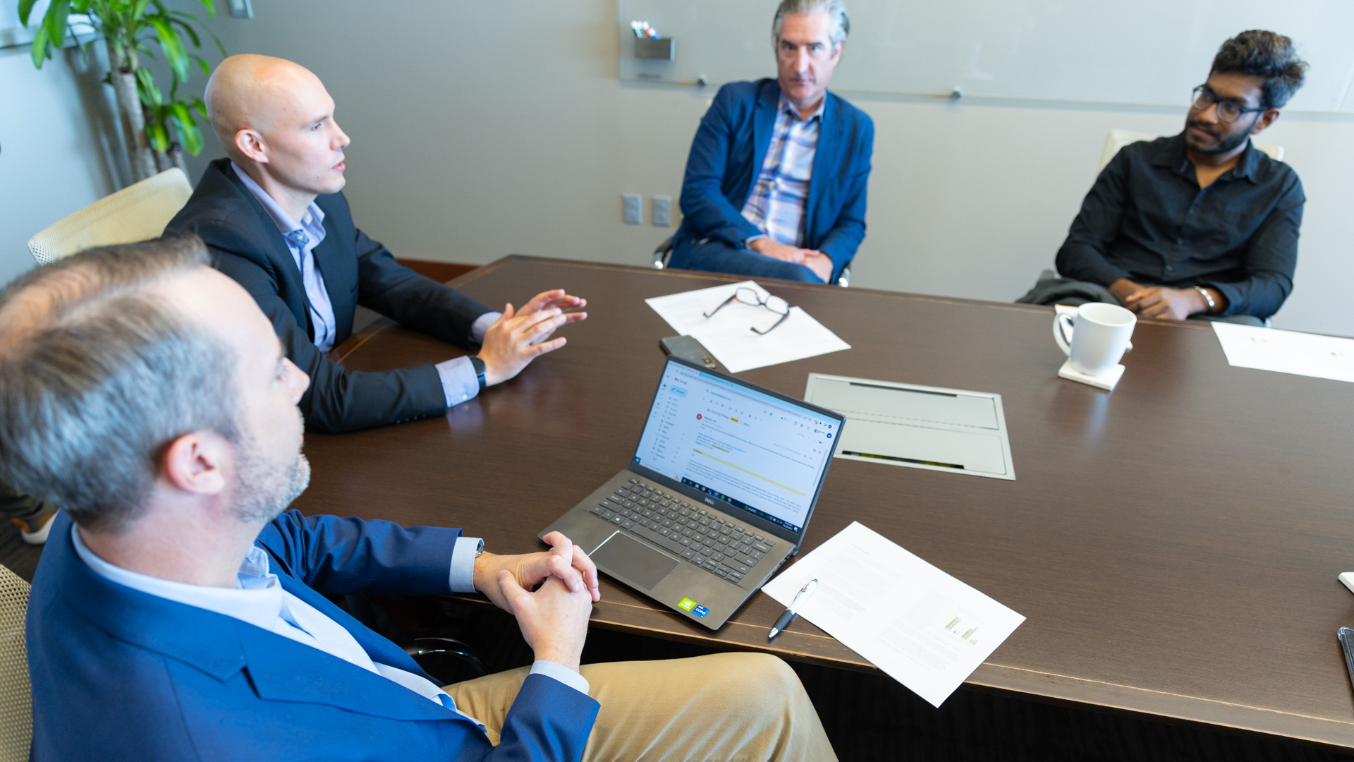 A group of professionals converse at a meeting table at the KU Innovation Park in Lawrence.