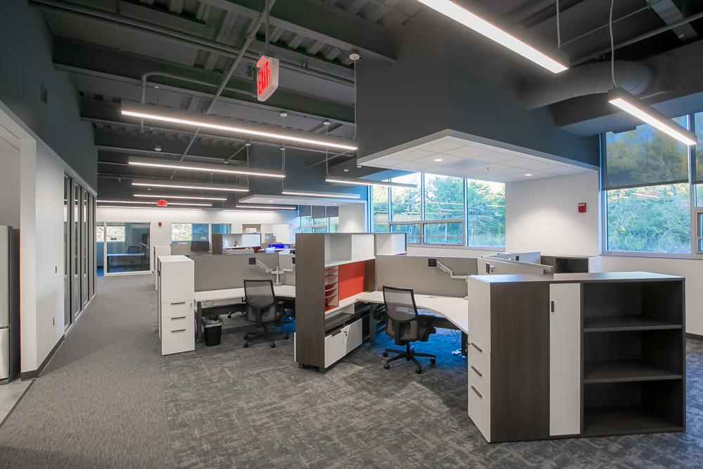 A gray office space with pods and storage at the A large empty lounge with red chairs at the KU Innovation Park in Lawrence.