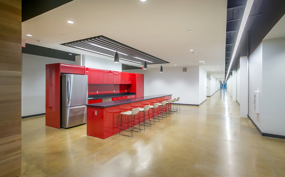 A large kitchen with red cabinets inside of the KU Innovation Park in Lawrence.