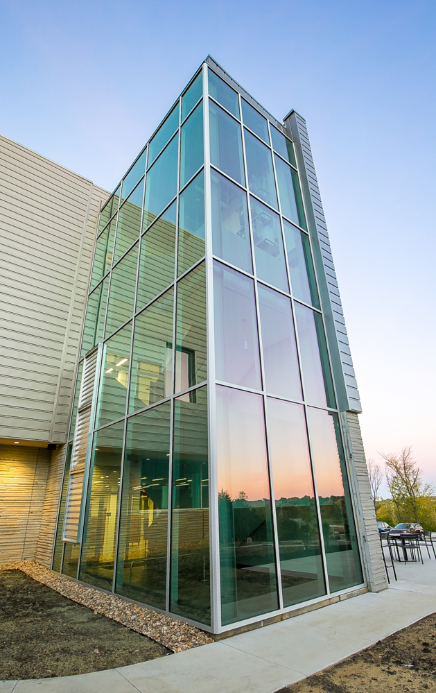 A tall glass enclosure reflects the sunset at the KU Innovation Park in Lawrence.