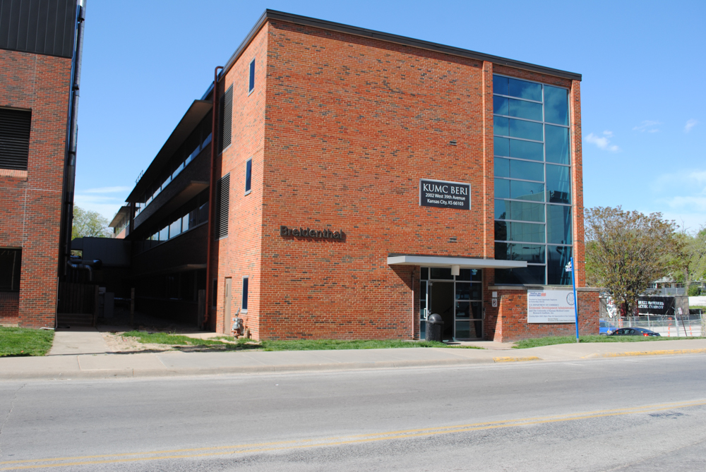 A brick building with a "KUMC BERI" sign at the KU Innovation Park in Kansas City by the KU Medical Center.