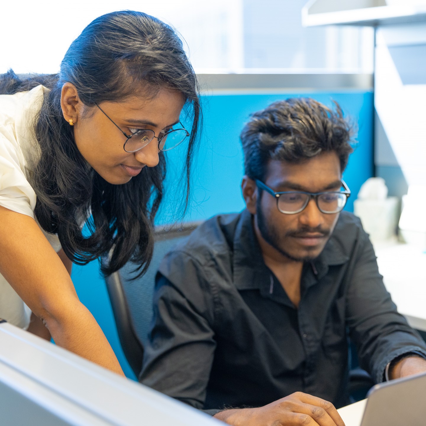 Two young professionals look at a computer together at the KU Innovation Park in Lawrence.