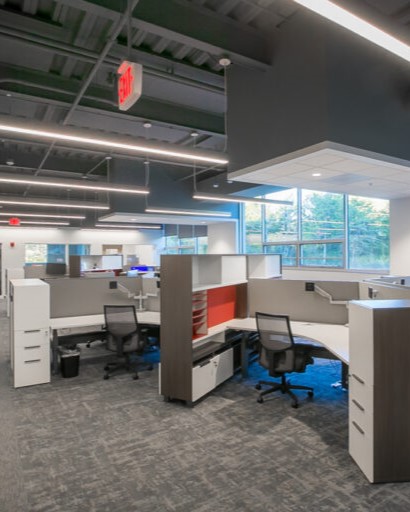 A man in a labcoat and other personal with protective equipment holds a long pipette in a lab at the Bioscience and Technology Business Incubator in Lawrence, KS.